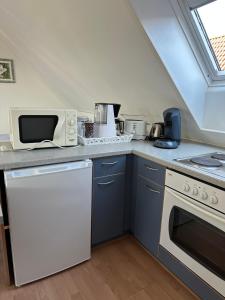 a kitchen with a white stove and a microwave at Birnbom Warnemünde in Warnemünde