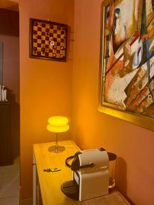 a table with a toaster and a yellow lamp on it at Appart G2 in Abidjan