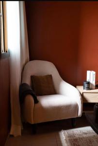 a white chair sitting in a room with a window at Appart G2 in Abidjan
