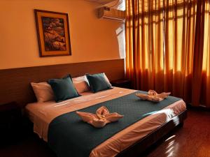 a bedroom with a bed with two flowers on it at Hotel Los Andes Inn in Guayaquil