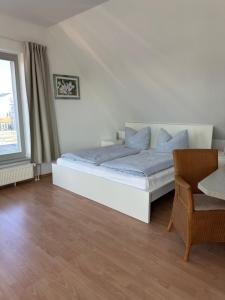 a bedroom with a bed and a chair and a window at Birnbom Warnemünde in Warnemünde