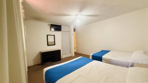 a hotel room with two beds and a ceiling fan at Hotel Plaza del Ángel in Huajuapan de León