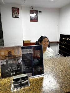 a woman sitting at a counter in a store at Hotel Los Andes Inn in Guayaquil