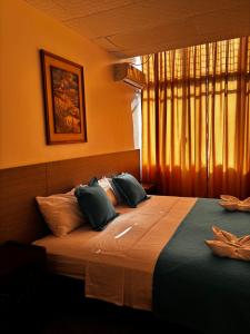 a bedroom with a bed with pillows and a window at Hotel Los Andes Inn in Guayaquil +19 photos