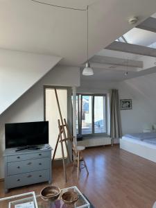 a bedroom with a bed and a dresser with a television at Birnbom Warnemünde in Warnemünde