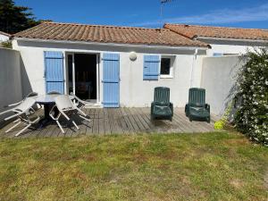 a patio with a table and chairs and a house at hirondelle 1 in Noirmoutier-en-l'lle