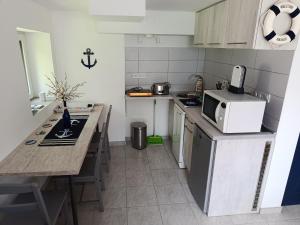 a small kitchen with a counter top and a microwave at Matróz Lak Apartman in Alsóörs