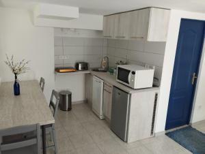 a small kitchen with a table and a microwave at Matróz Lak Apartman in Alsóörs