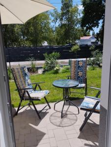 a patio with a table and two chairs and an umbrella at Matróz Lak Apartman in Alsóörs