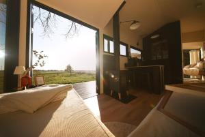 a bedroom with a bed and a large window at NOAH Cabin No2 - An wunderschöner Windmühle in Beverstedt