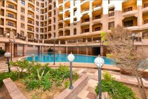 a large building with a swimming pool in front of it at Green View Compound Apartment in Alexandria