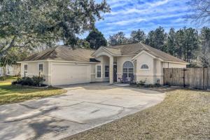 a white house with a fence and a driveway at Relaxed Poolside Gym Escape in Green Cove Springs