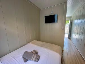 a room with a bed and a tv on the wall at 12 · Studio 22 Itajaí microcasa in Itajaí