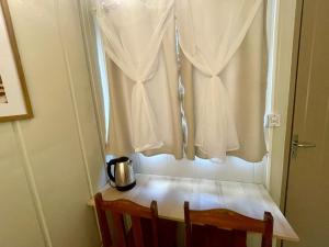 a table with a tea kettle and a window at 12 · Studio 22 Itajaí microcasa in Itajaí