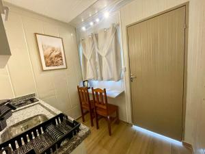 a kitchen with a sink and a table and a door at 12 · Studio 22 Itajaí microcasa in Itajaí