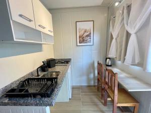 a kitchen with a stove and a counter top at 12 · Studio 22 Itajaí microcasa in Itajaí