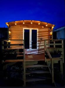 a cabin with lights on the deck at night at La Roulotte des Gaillots in Moiremont +4 photos