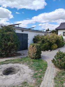 a white house with a black garage at Noclegi na winnicy in Dys