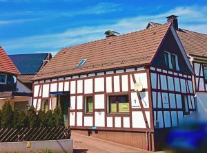 a white and black house with a red roof at Ferienhaus Medebach in Medebach