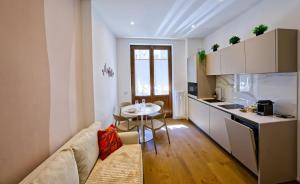 a living room with a couch and a table in a kitchen at NS Urban Suite in Udine +25 photos