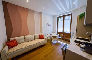 a living room with a couch and a table at NS Urban Suite in Udine