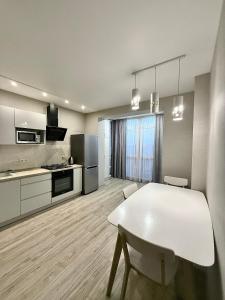 a kitchen with a white table and a white dining room at Apartment Versailles Park 1 in Irpin