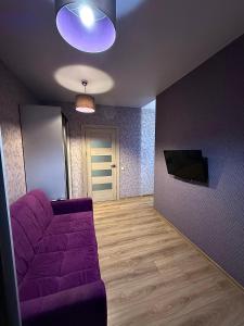a living room with a purple couch and a tv at Apartment Versailles Park 1 in Irpin