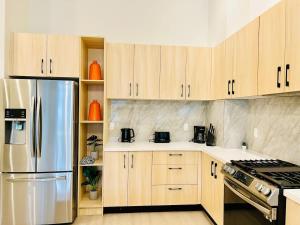 a kitchen with wooden cabinets and a stainless steel refrigerator at Family Friendly Ground Level Condo in Surrey