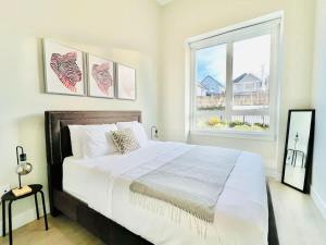 a bedroom with a large bed and a window at Family Friendly Ground Level Condo in Surrey
