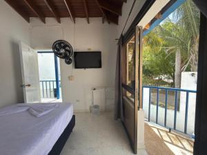 ein Schlafzimmer mit Bett und ein Balkon mit Fernseher in der Unterkunft Hotel Astoria in Melgar