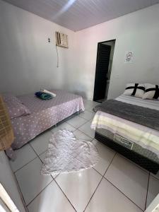 a bedroom with two beds and a tiled floor at Pousada são Martins in Estivado
