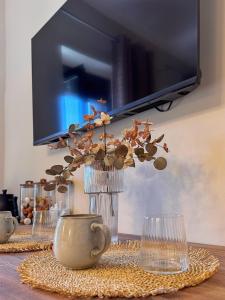 a vase with flowers in it on a table at Gregory Central Apartment in Chania
