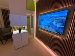 a living room with a television on a wall at Apartments Vila Ardi in Sarandë