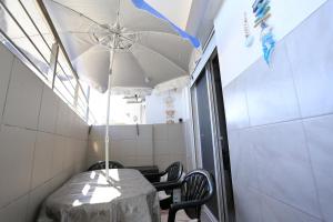 a table with a white umbrella in a room at Billis Cologne Apartment in Flogita