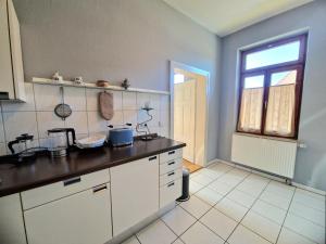 a kitchen with white cabinets and a window at Ferienwohnung am Schlossplatz in Wolfegg +21 photos