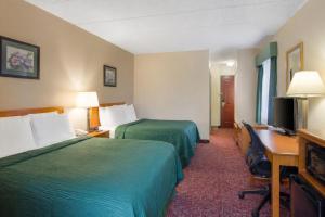 a hotel room with two beds and a desk and a television at All Seasons Inn & Suites Smithfield Providence in Smithfield +39 photos