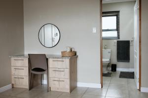 a bathroom with a vanity with a mirror and a toilet at Melk en Heuning Uitspan in Orania +28 photos