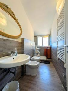 a bathroom with a sink and a toilet and a mirror at ESPRESSO VISTA MARE, Ostia Antica in Lido di Ostia