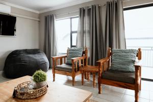 a living room with two chairs and a table at Melk en Heuning Uitspan in Orania