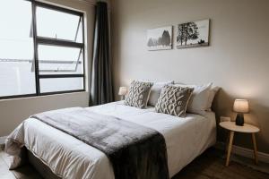 a bedroom with a white bed with a window at Melk en Heuning Uitspan in Orania