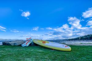 a yellow kayak sitting on the grass near the water at Luxurious 7BR Walk 2 Beach and Bus Stop in Carnelian Bay
