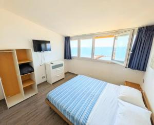 a bedroom with a bed and a window and a television at ESPRESSO VISTA MARE, Ostia Antica in Lido di Ostia