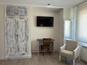 a room with a table and a chair and a door at Pensión O Prouso in San Mamede de Carnota