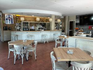 a restaurant with wooden tables and chairs and a bar at Pensión O Prouso in San Mamede de Carnota