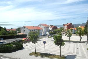 a street with trees and houses in a city at Pensión O Prouso in San Mamede de Carnota