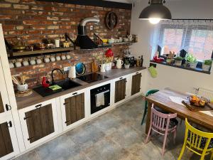 a kitchen with a table and a brick wall at Dobków 42 in Dobków