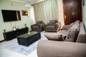 a living room with couches and a flat screen tv at Jeswel Lux villa in Dodoma +7 photos