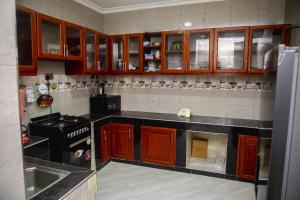 a kitchen with wooden cabinets and a stove top oven at Jeswel Lux villa in Dodoma