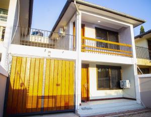 a house with a yellow door and a balcony at Jeswel Lux villa in Dodoma