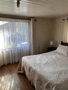 a bedroom with a white bed and a window at Hospedaje Lala in Villarrica